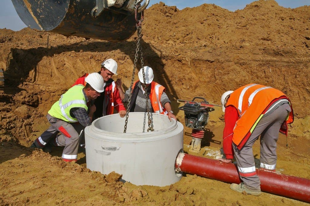 Pose d’un regard d’assainissement en béton avec canalisation — illustration travaux réseaux