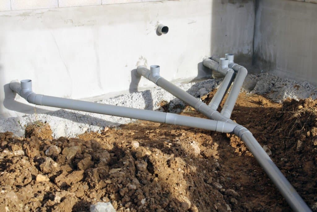 Réseau d’eaux pluviales en PVC contre façade — illustration travaux assainissement